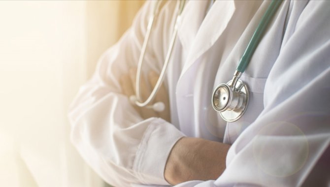 Doktor önlüğüyle hastanede, mikrofon başında radyoda